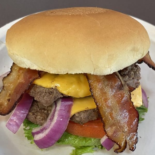 A double bacon cheeseburger from Go To Burgers, with lettuce, tomato, and red onion.